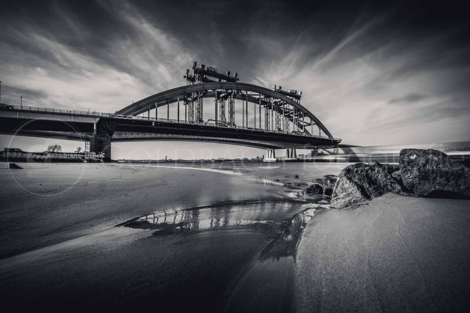 De oude Lekbrug onder langgerekte wolken, het water spiegelglad door de lange sluitertijd