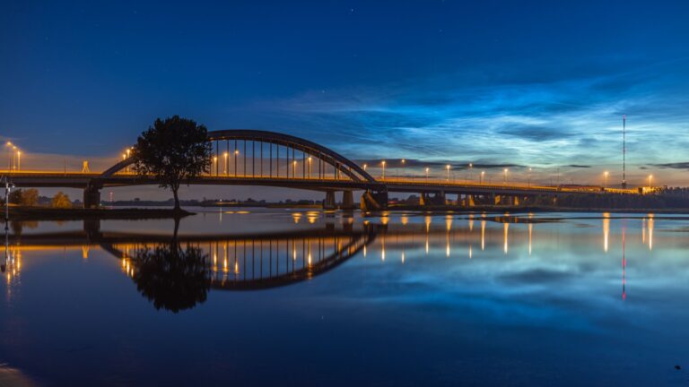 Bureaubladachtergrond: lichtende nachtwolken boven de Lekbrug